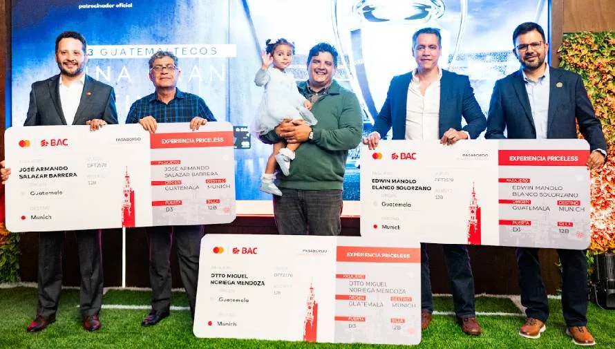 5 hombres sosteniendo carteles, al centro una niña siendo cargada y saludando